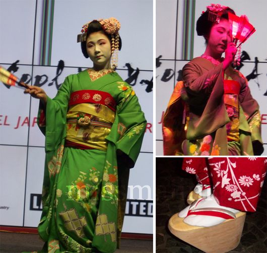 A Geisha girl in full costume performs the traditional fan dance