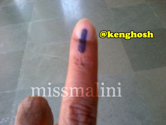 Director Ken Ghosh shows off his finger after voting
