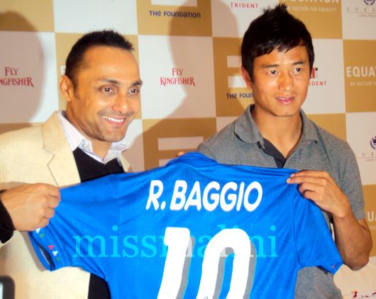 Rahul Bose and Bhaichung Bhutia hold up a jersey autographed by footballer, Roberto Baggio
