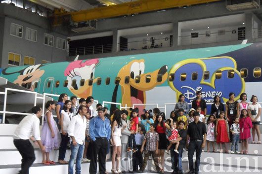 The winners and their families pose against the plane