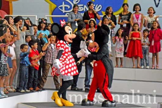 Mickey and Minnie Mouse entertain the children who won the contest