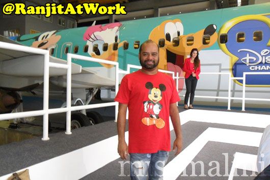 Ranjit poses against the Disney plane by Jet Airways