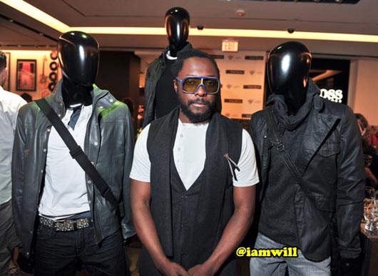 Will.I.Am strikes a pose with the display of his garments from his I Am Clothing line
