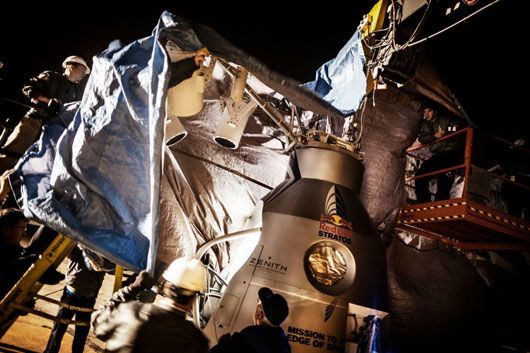 Crew members uncover the capsule during the preparation for the final manned flight of Red Bull Stratos