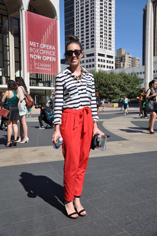 Fashionable attendee turns heads in an effortless striped blouse and a bright pair of peg pants.