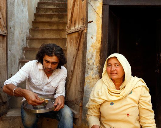 Imtiaz Ali enjoys a meal at a local resident's house during Highway
