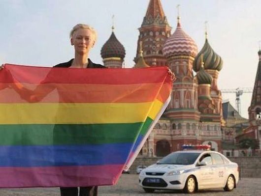 Tilda Swinton holds a rainbow flag in front of Moscow's Kremlin