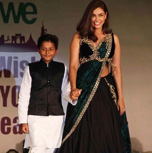Lisa walking the ramp with a kid for a fashion show