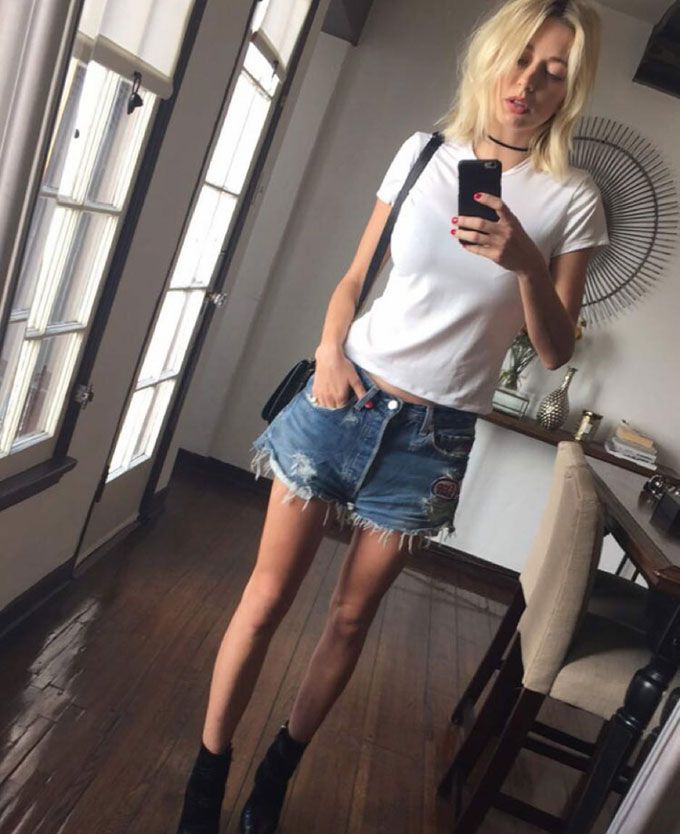 Basic white tee, ripped daisy duke shorts, booties and the '90s choke neck-piece (Pic: @carolinavreeland on Instagram)