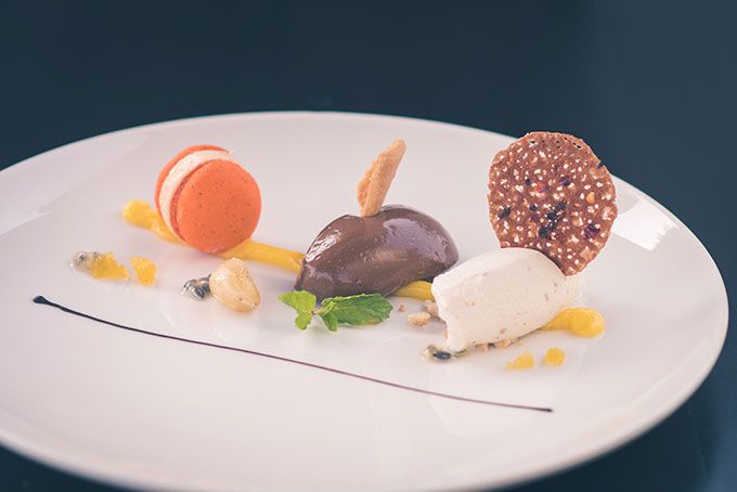 Chocolate custard, Chikoo Icecream, Papaya Mousse, Cocoa & Chilli Tuille, Roasted Peanut Crumbs, Macaron, Passion Fruit sauce and Candied Cashew nuts