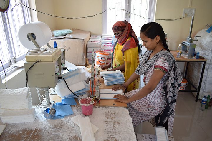 Bhanuben (left) and Asha (right) assembling sanitary napkins (Photo: Romeo Gates)