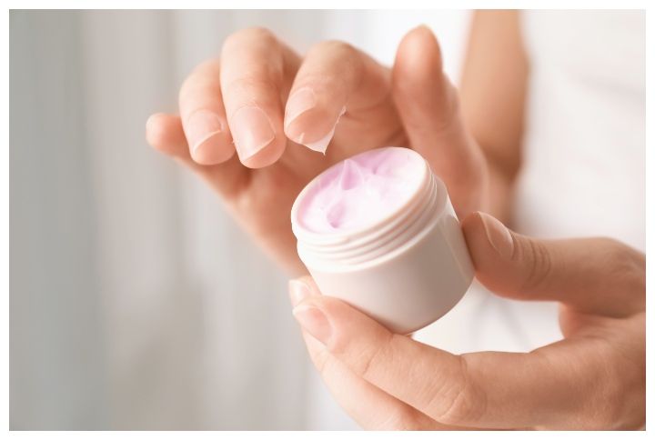 Young woman holding jar of hand cream by Africa Studio | www.shutterstock.com