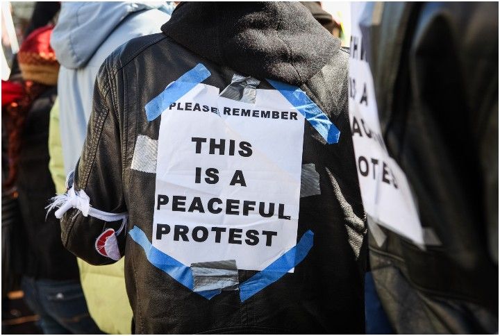 Protesters with a 'This is a peaceful protest' sign by Suzanne Tucker | www.shutterstock.com