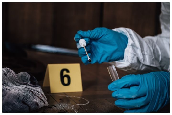 Forensic Investigator collecting blood evidence from a crime scene by Microgen | www.shutterstock.com