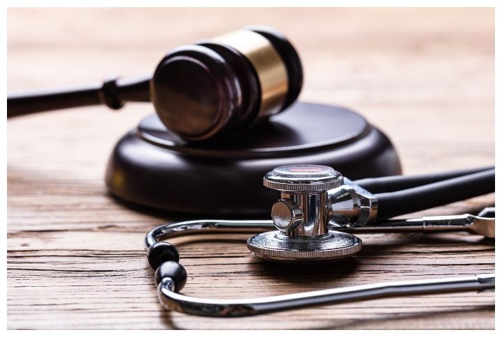 A stethoscope and a gavel on a wooden desk by Andrey_Popov | www.shutterstock.com