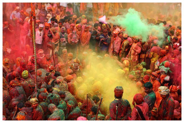 People throw colors at each other during the Holi celebration in Nandgaon, India by AJP | www.shutterstock.com