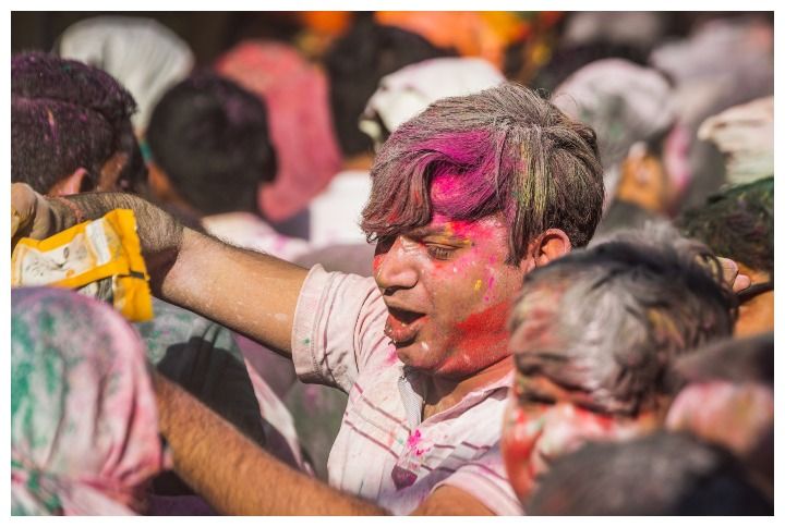 People covered in different colours celebrating Holi in Vrindavan, India by Ruslan Kalnitsky | www.shutterstock.com