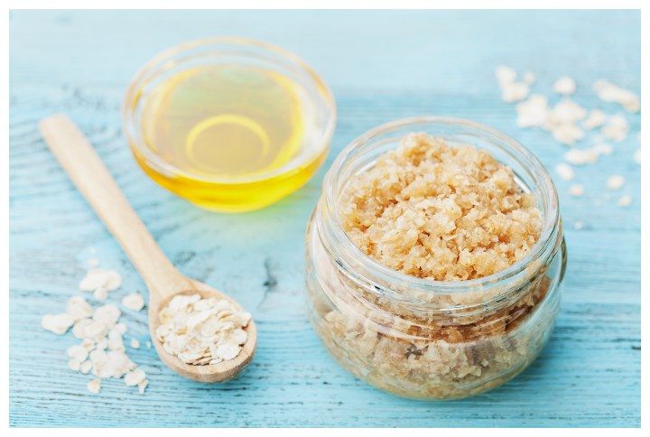 Body scrub of oatmeal, sugar, honey and oil in glass jar on blue rustic table, homemade cosmetic for peeling and spa care by Julia | (Source: www.shutterstock.com)