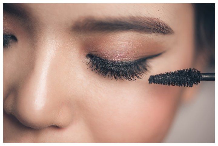 Close-up portrait of beautiful girl touching black mascara to her lashes makeup by Makistock | (Source: www.shutterstick.com)