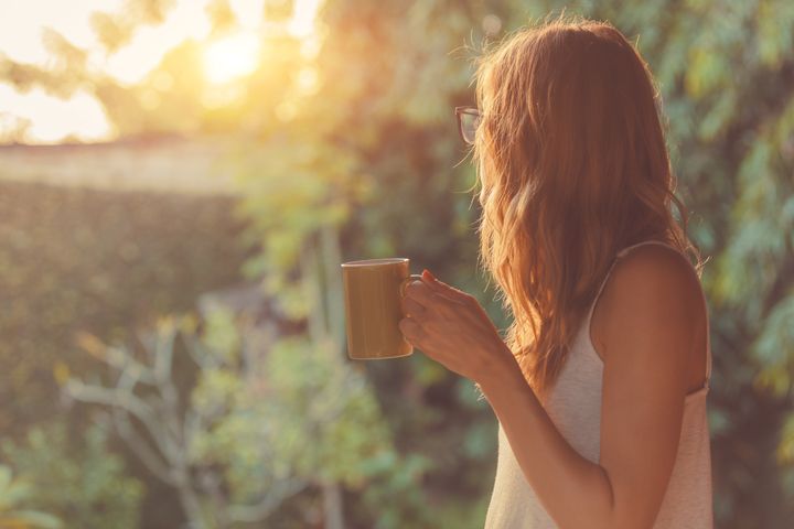 Cute girl enjoying morning coffee on the porch By AstroStar | www.shutterstock.com