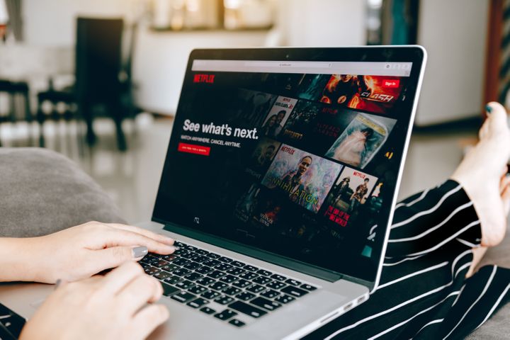 Woman in Pj’s using laptop to watch Netflix By wutzkohphoto | www.shutterstock.com