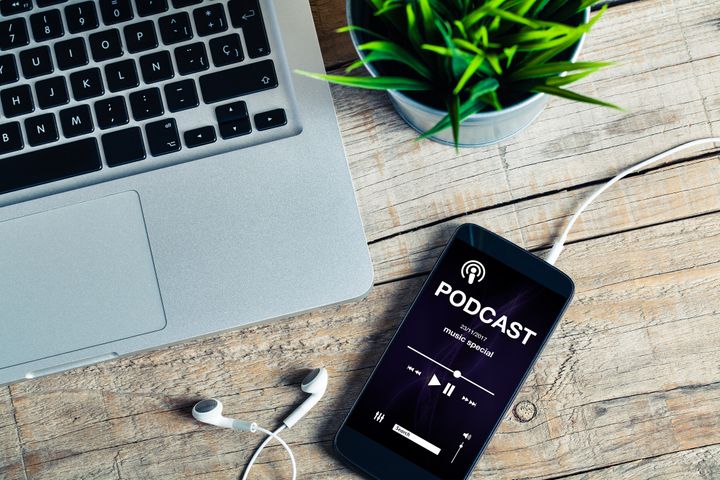 Podcast app in a mobile phone at the office By David MG | www.shutterstock.com