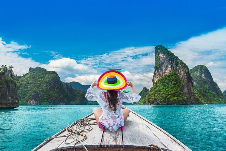 Traveler woman in summer dress relaxing on wooden boat joy view of Phang Nga bay, near Phuket, Travel in nature place Thailand, Beautiful destination Asia, Summer holiday outdoor vacation travel trip by Day2505 | www.shutterstock.com