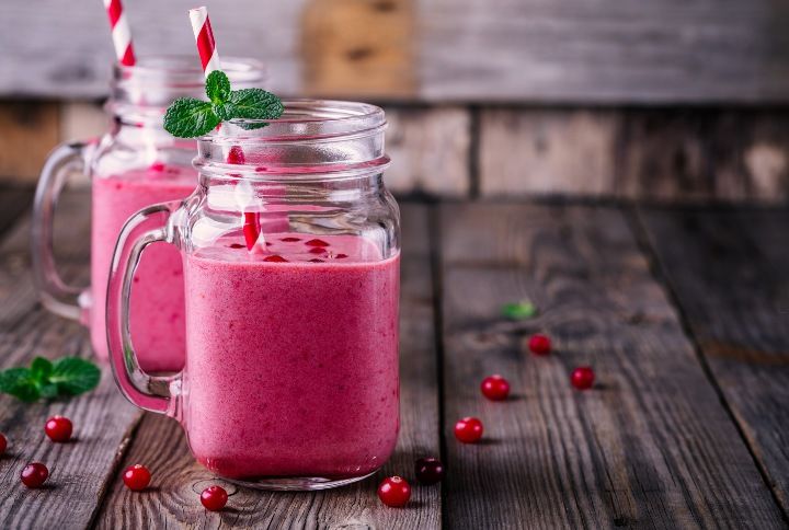 pink smoothie with wild cranberries in mason jar with mint and straw on rustic wooden background By Ekaterina Kondratova | www.shutterstock.com