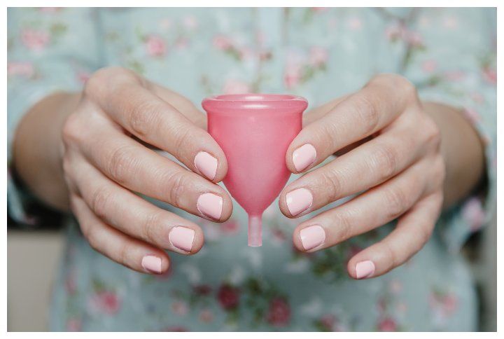 Woman holding a menstrual cup by By David Pereiras | www.shutterstock.com