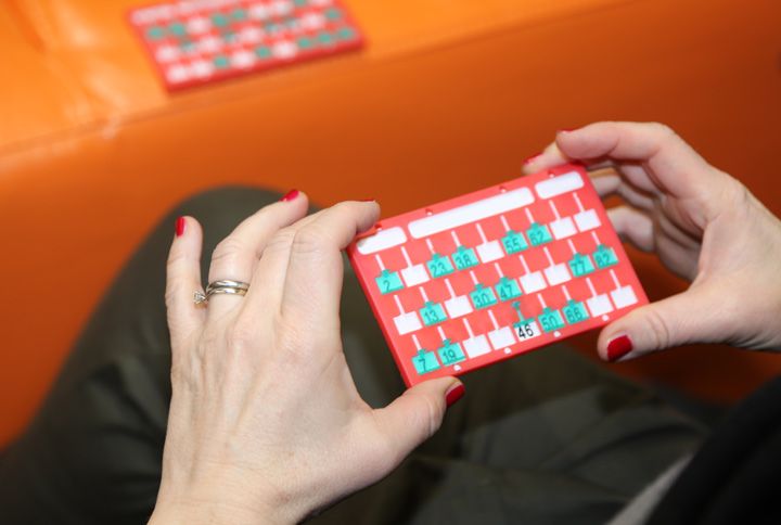 Bingo Scorecards And The Hand Of A Woman Player By ChiccoDodiFC | (Source: Shutterstock)
