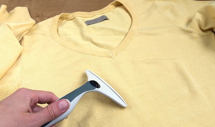 Female Hands Removes Fuzz From Sweater by Far_away | www.shutterstock.com