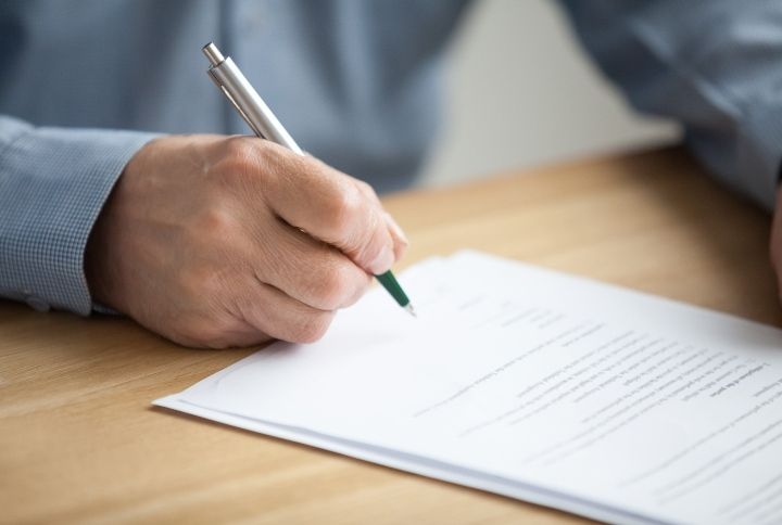 Man Signing Legal Document By fizkes | www.shutterstock.com