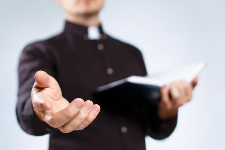 Wedding Preparation Course where young priest reads from the Holy Bible By Yeti studio | www.shutterstock.com