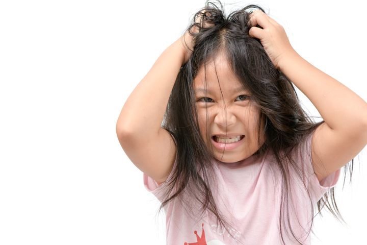 Girl with an itch in her hair from lice By kwanchai.c | www.shutterstock.com
