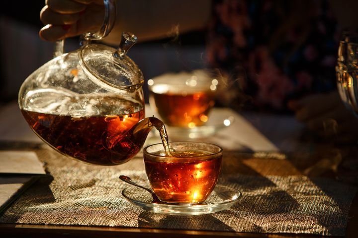 Pouring tea into a tea-cup. By Coy_Creek | www.shutterstock.com