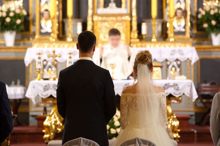 Priest celebrates wedding mass at a church By wideonet | www.shutterstock.com