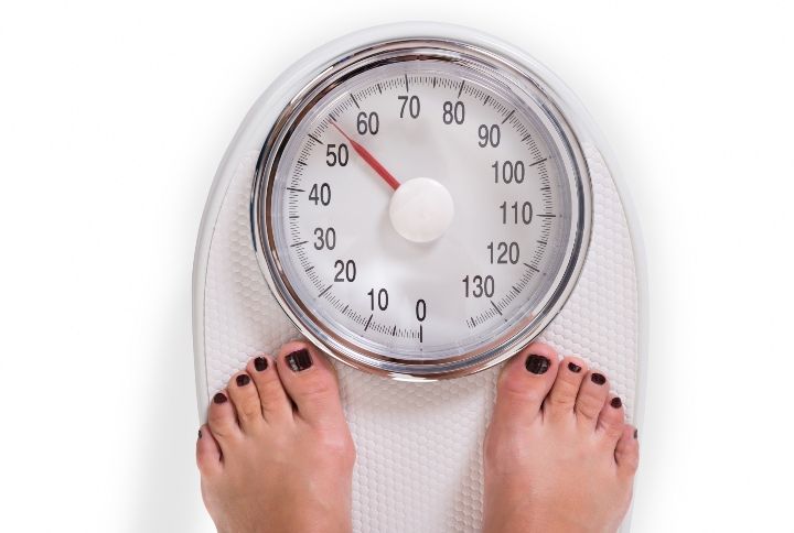 Woman On A Weighing Scale By Andrey_Popov | www.shutterstock.com