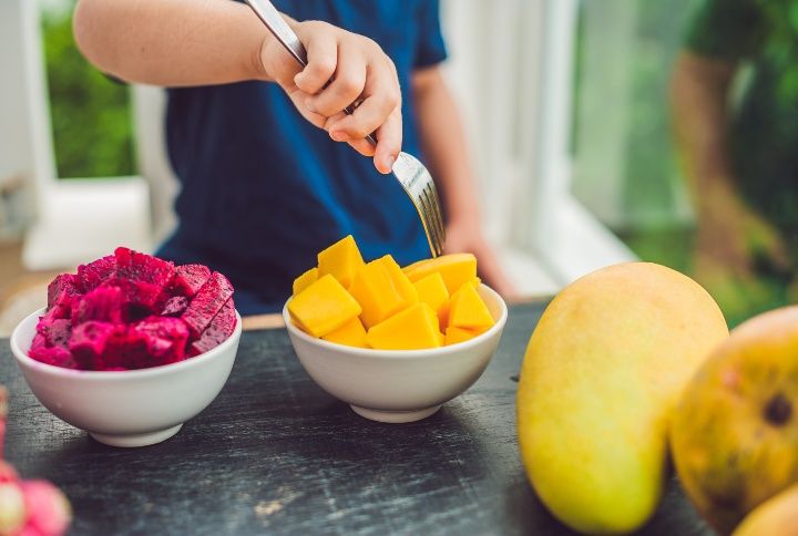 Little Boy Eating Mangoes By Elizaveta Galitckaia | www.shutterstock.com