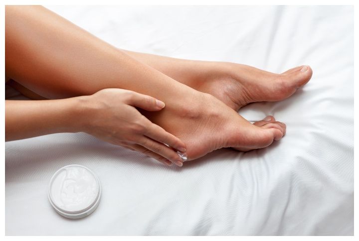 Woman caring about her feet and putting hydrating cream on it by Cherries | www.shutterstock.com
